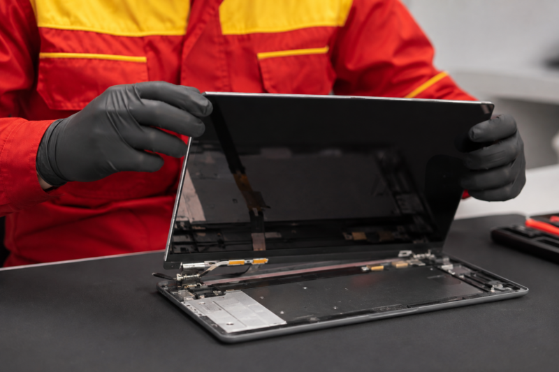 Serwisant naprawia laptop Asus, otwarta obudowa z widoczną matrycą i zawiasami w Warszawie